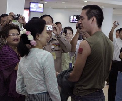 လက္ေမာင္းတြင္ ေရးထိုးထားသည့္ NLD အလံ ေဆးမွင္ေၾကာင္အား မိခင္ျဖစ္သူကို ျပသစဥ္ (AP Photo/Khin Maung Win)
